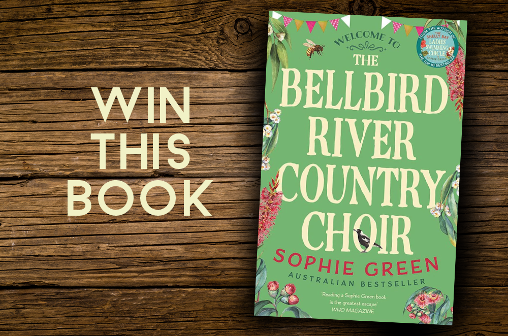 Cover artwork for The Bellbird River Country Choir by author Sophie Green on a wooden table with ‘Win This Book’ beside it.